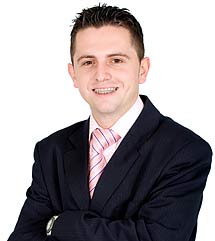 photo of a smiling young man wearing braces and a power suit